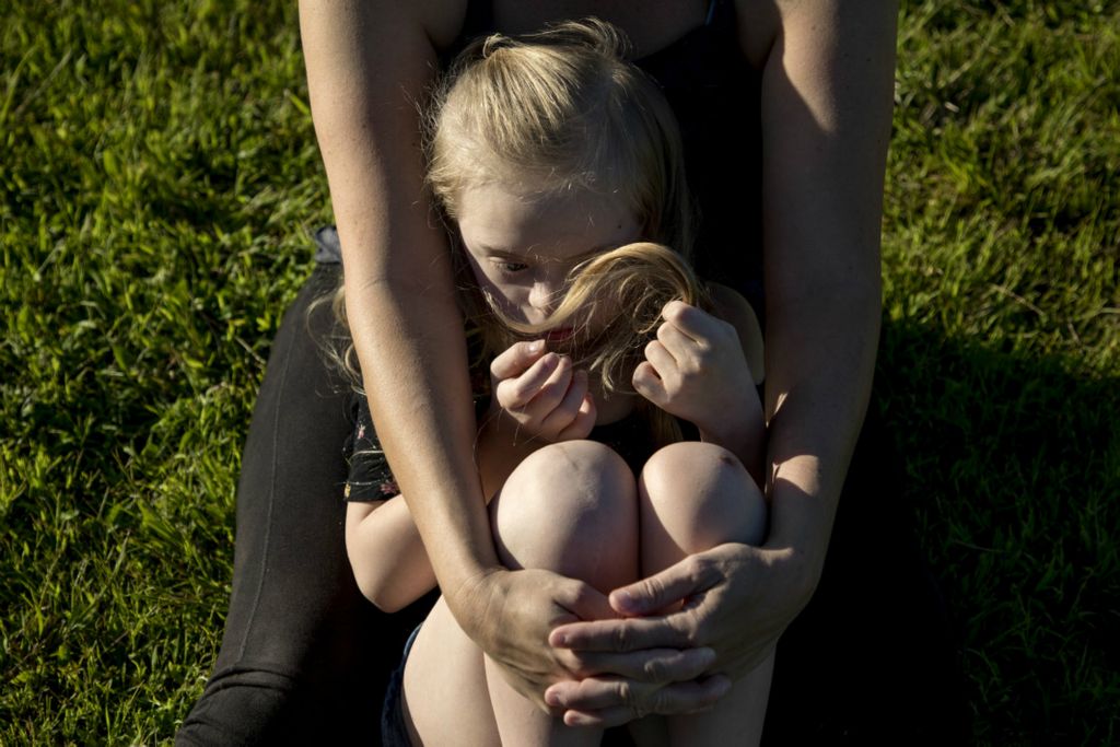First Place, Feature Picture Story - Jessica Phelps / Newark Advocate, “Living on Love”Leah Hrebluk holds her youngest daughter, Kyndall, in her arms at TJ Evans Park while she chit chats with a friend in August 2019. Leah, who is a single mom is raising two special needs daughters, Kyndall who has Down syndrome, and Sophia who has Cerebral Palsy. 